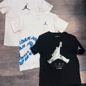 Pack of 3 shirts. 1 Jordan Kids' Black T shirt and 2 White T-Shirts